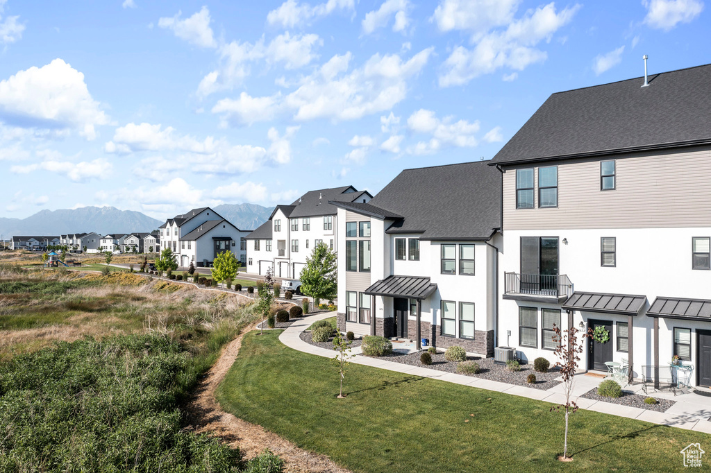 Exterior space with a yard, a mountain view, and a balcony