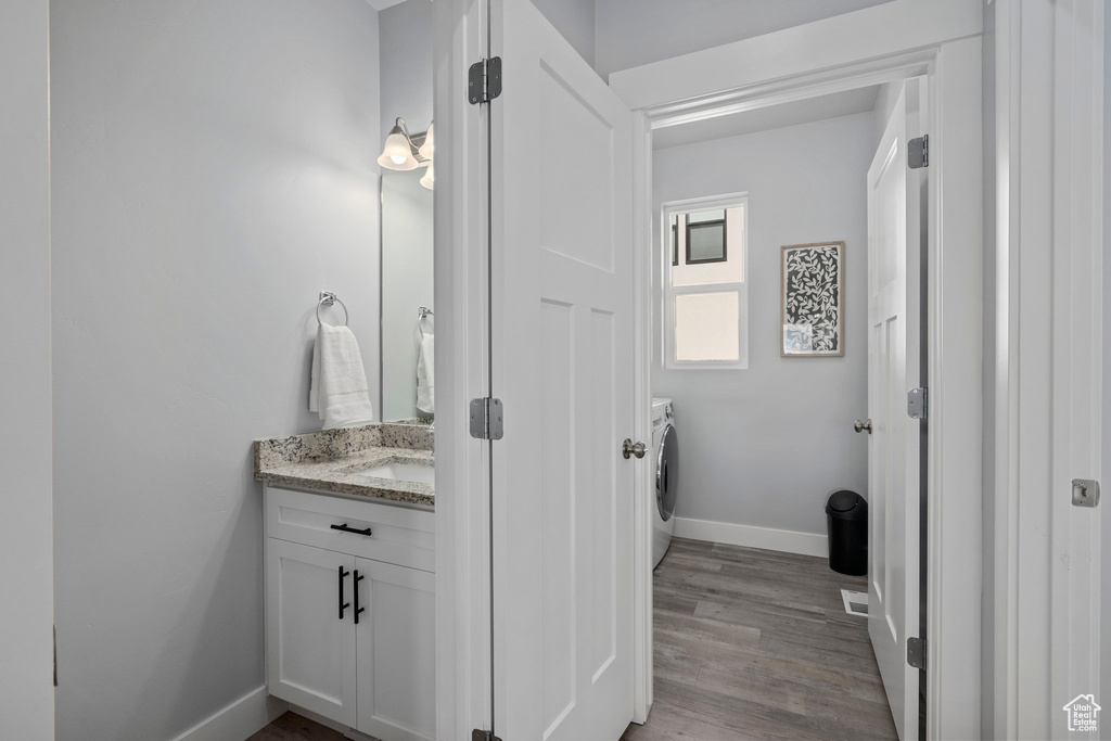 Bathroom featuring hardwood / wood-style flooring, vanity, and washer / clothes dryer