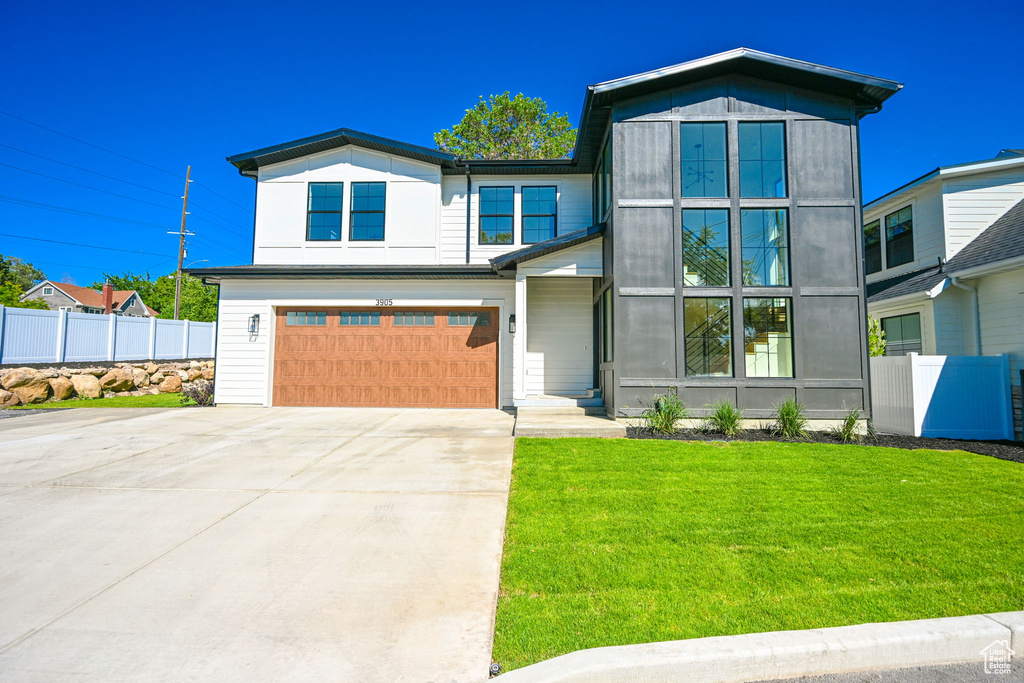 View of front of house featuring a front yard and a garage