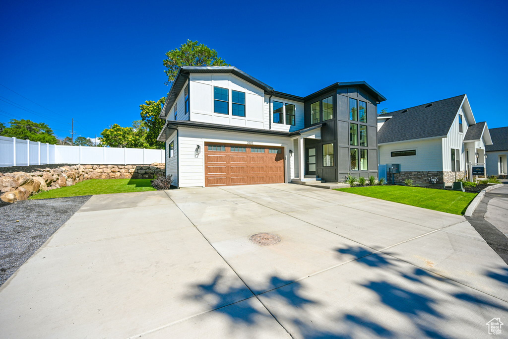 View of front of home featuring a front lawn and a garage