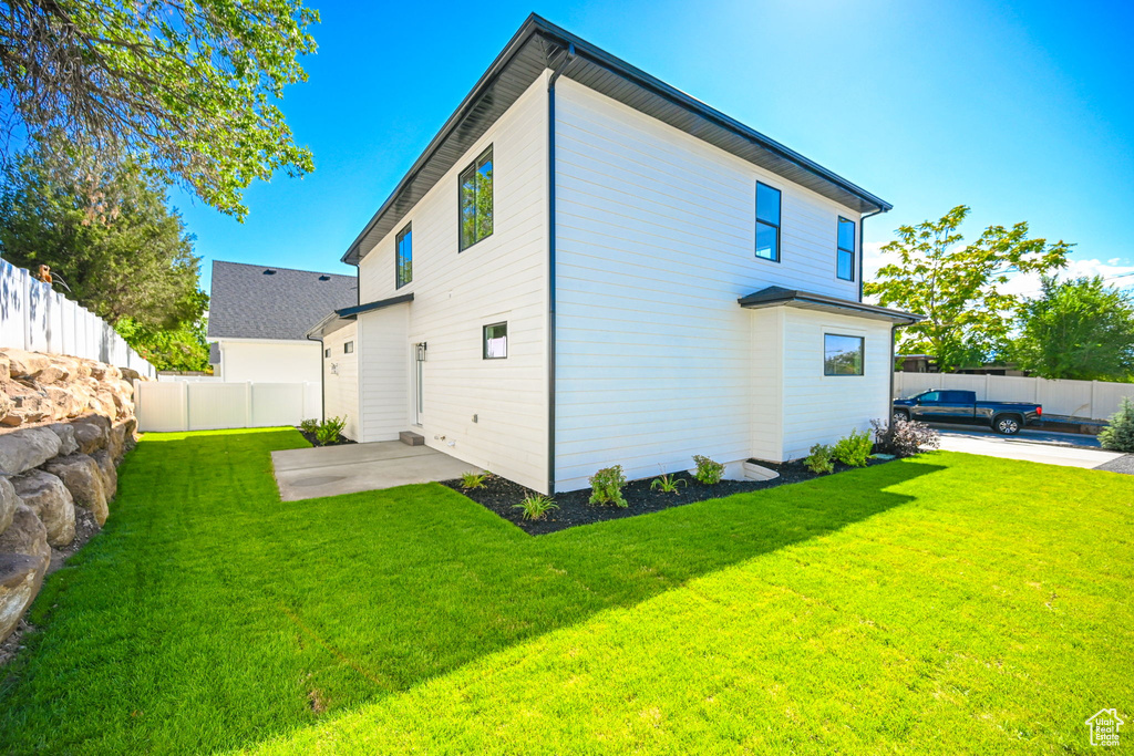 Rear view of house with a lawn and a patio area