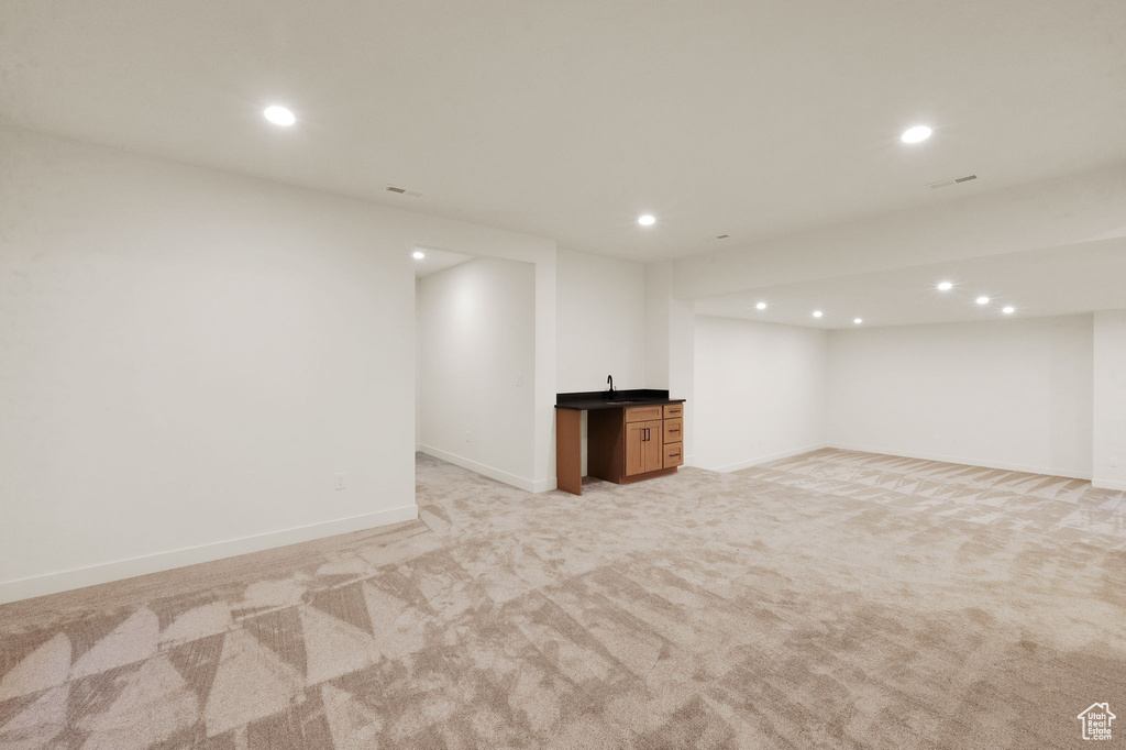 Basement featuring light carpet