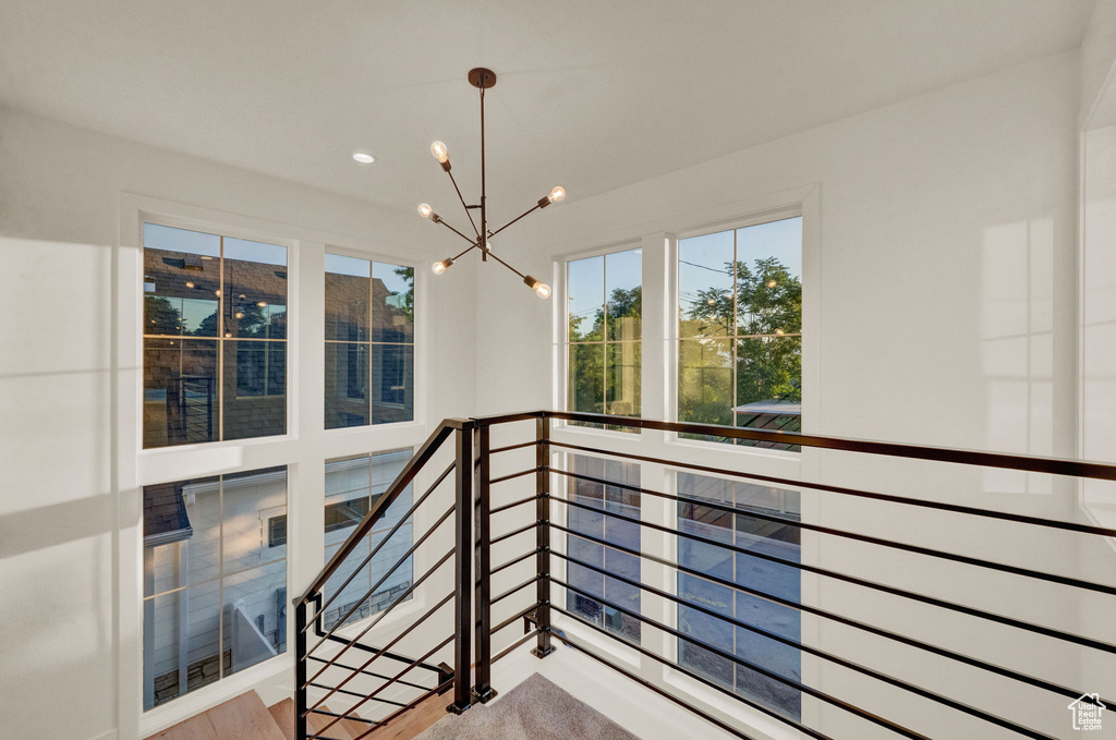 Stairs featuring a notable chandelier and hardwood / wood-style flooring