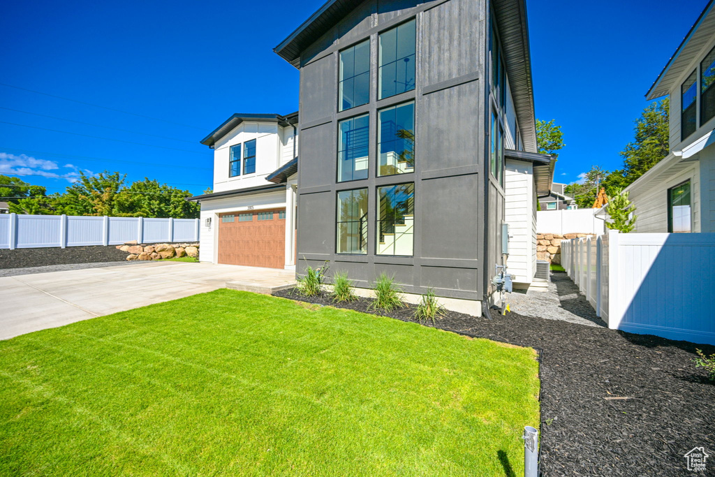 Contemporary house featuring a front yard and a garage