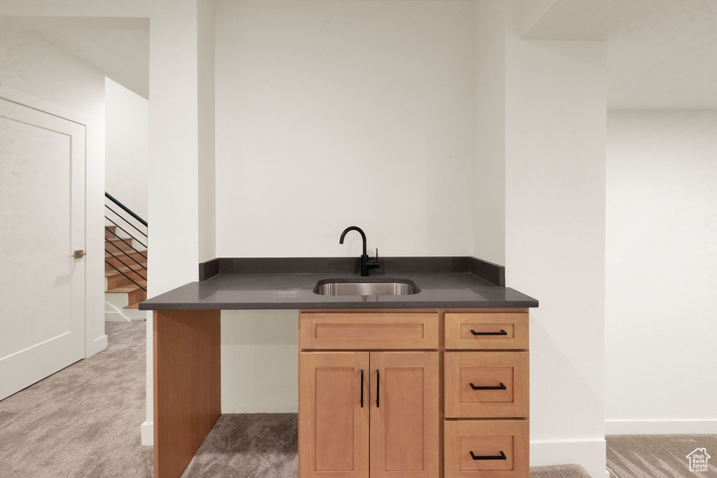 Kitchen featuring sink, light brown cabinetry, and light colored carpet