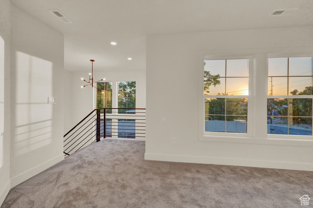 Spare room with an inviting chandelier and carpet floors