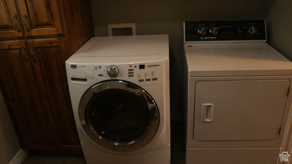 Clothes washing area with washing machine and clothes dryer, washer hookup, and cabinets