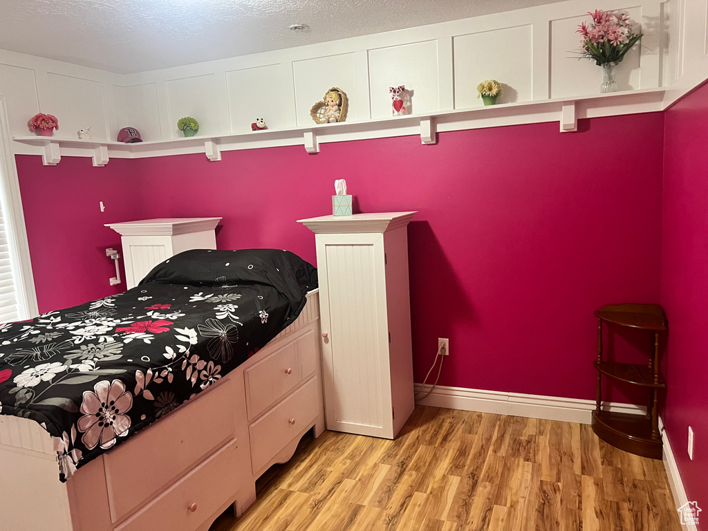 Bedroom featuring a textured ceiling and light wood-type flooring