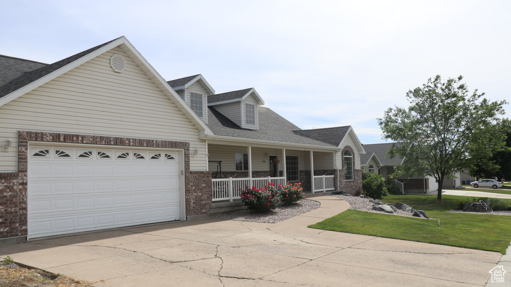 View of front of house featuring a garage and a porch