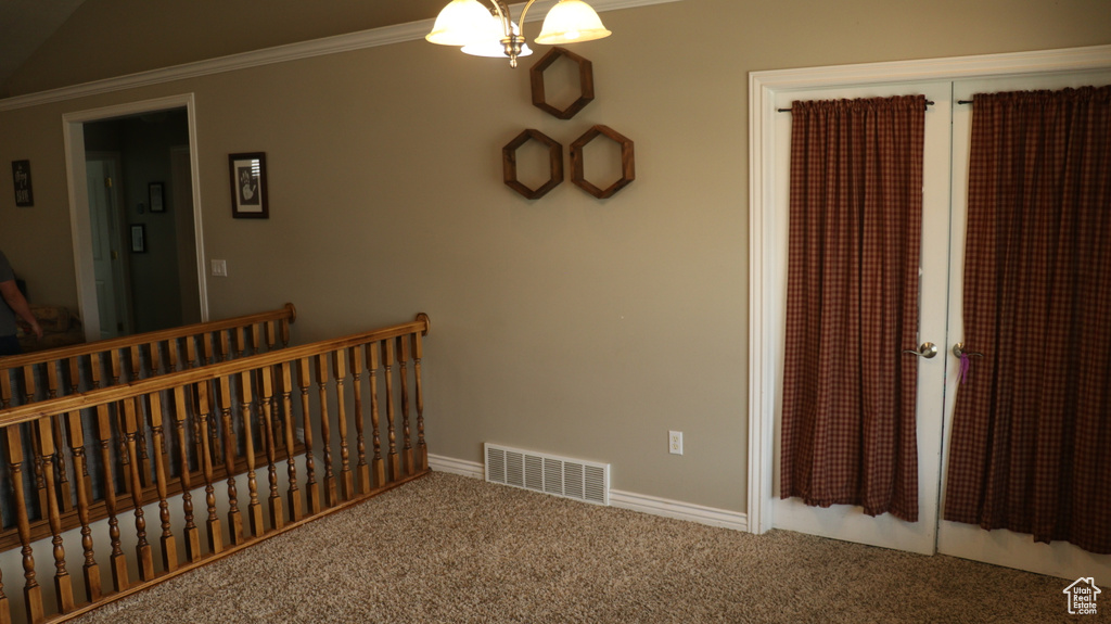 Stairway with ornamental molding, carpet, and vaulted ceiling