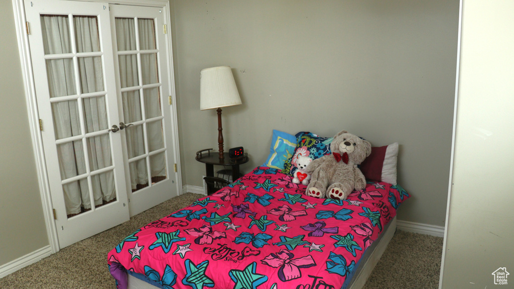 Carpeted bedroom featuring french doors