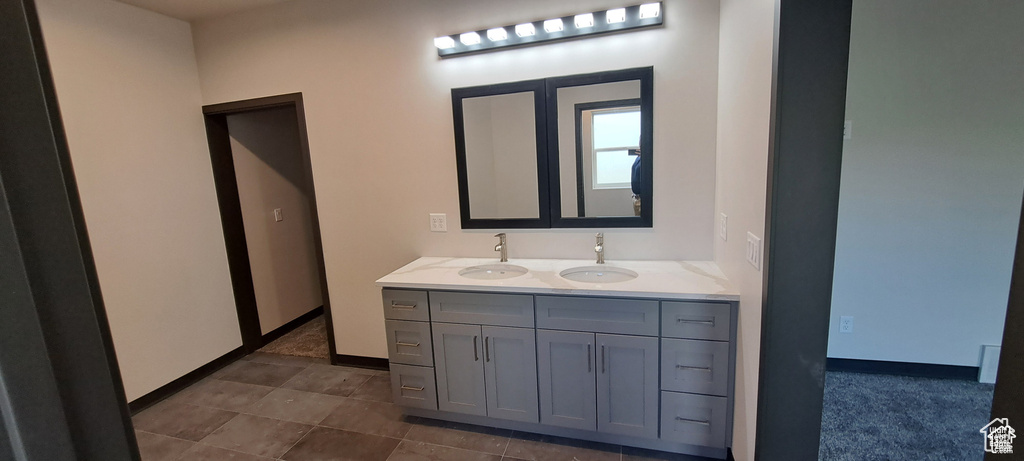 Bathroom featuring tile floors and double vanity