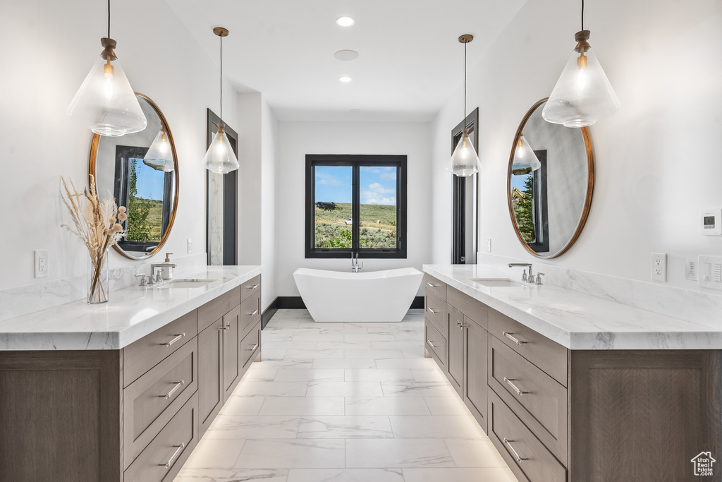 Bathroom with a tub, tile flooring, and vanity