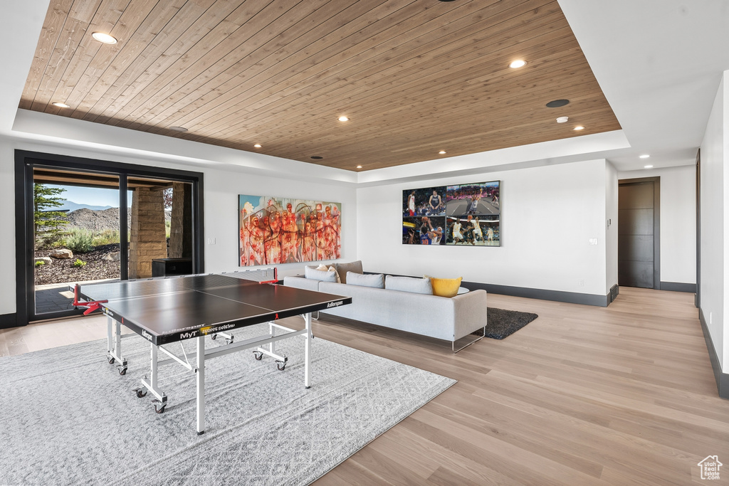 Playroom featuring a tray ceiling, light hardwood / wood-style flooring, and wood ceiling