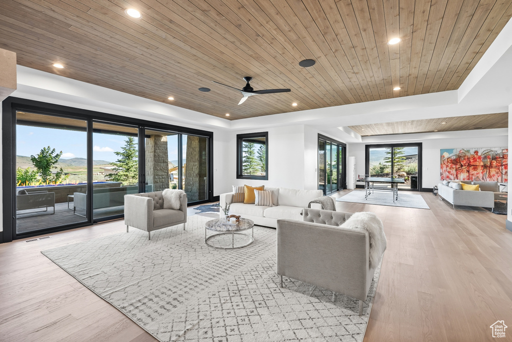 Living room featuring ceiling fan, light hardwood / wood-style flooring, and wooden ceiling