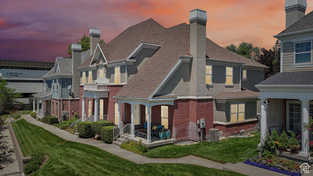 Back house at dusk featuring a yard