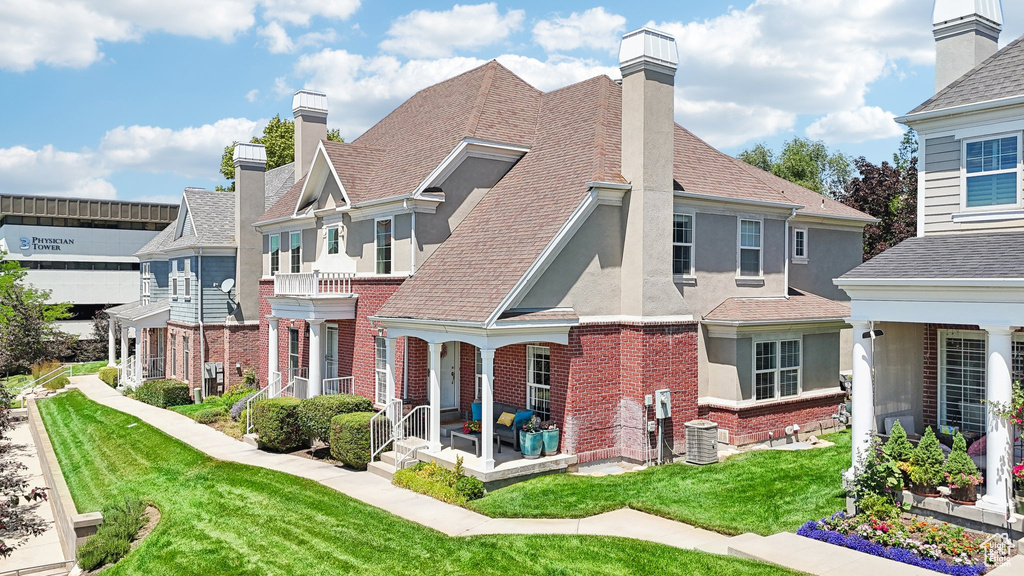 Rear view of house with covered porch and a lawn