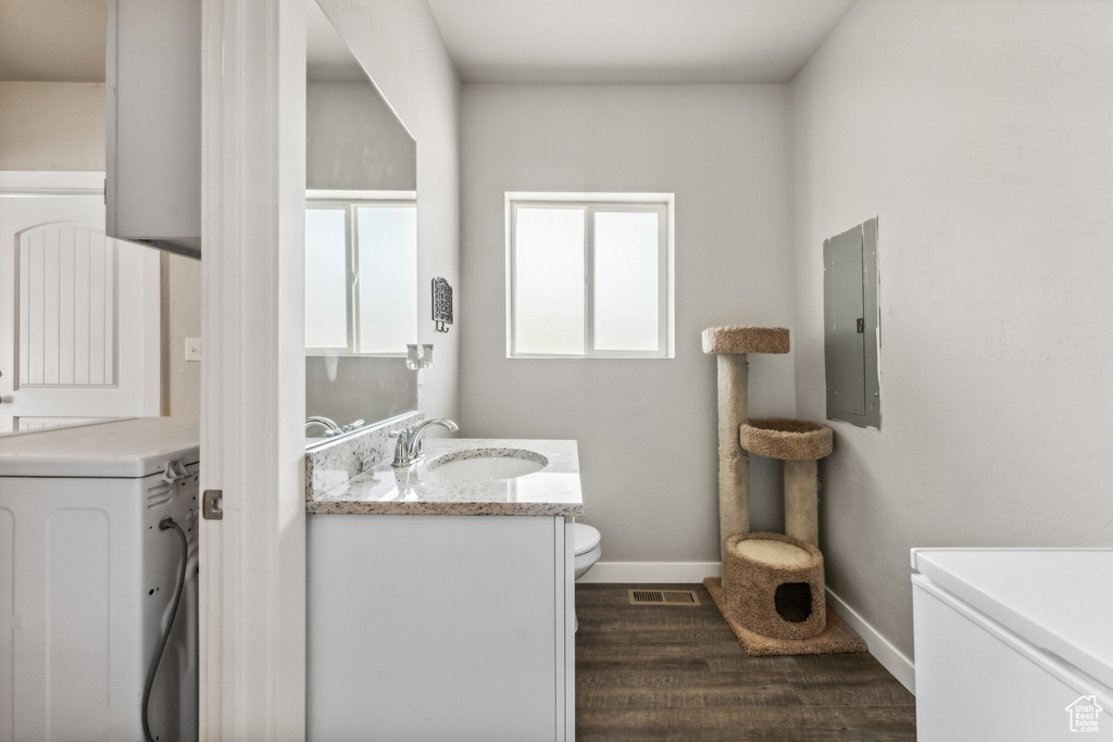 Bathroom with hardwood / wood-style floors, toilet, and vanity