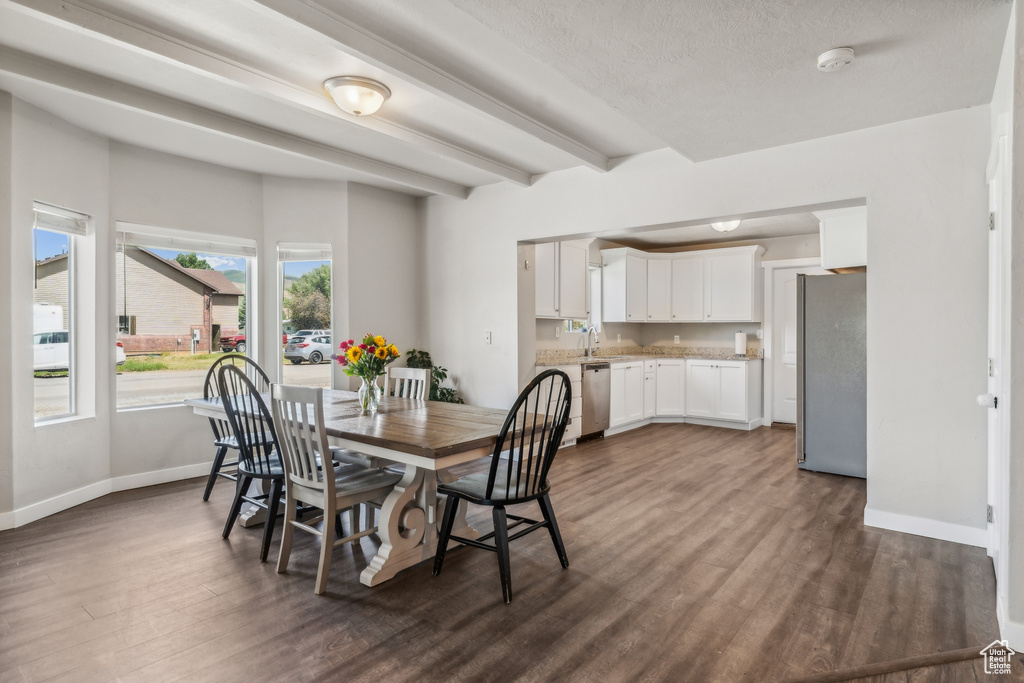 Dining room with sink, dark hardwood / wood-style flooring, and a textured ceiling