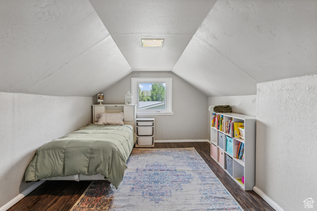 Bedroom featuring dark hardwood / wood-style floors and vaulted ceiling