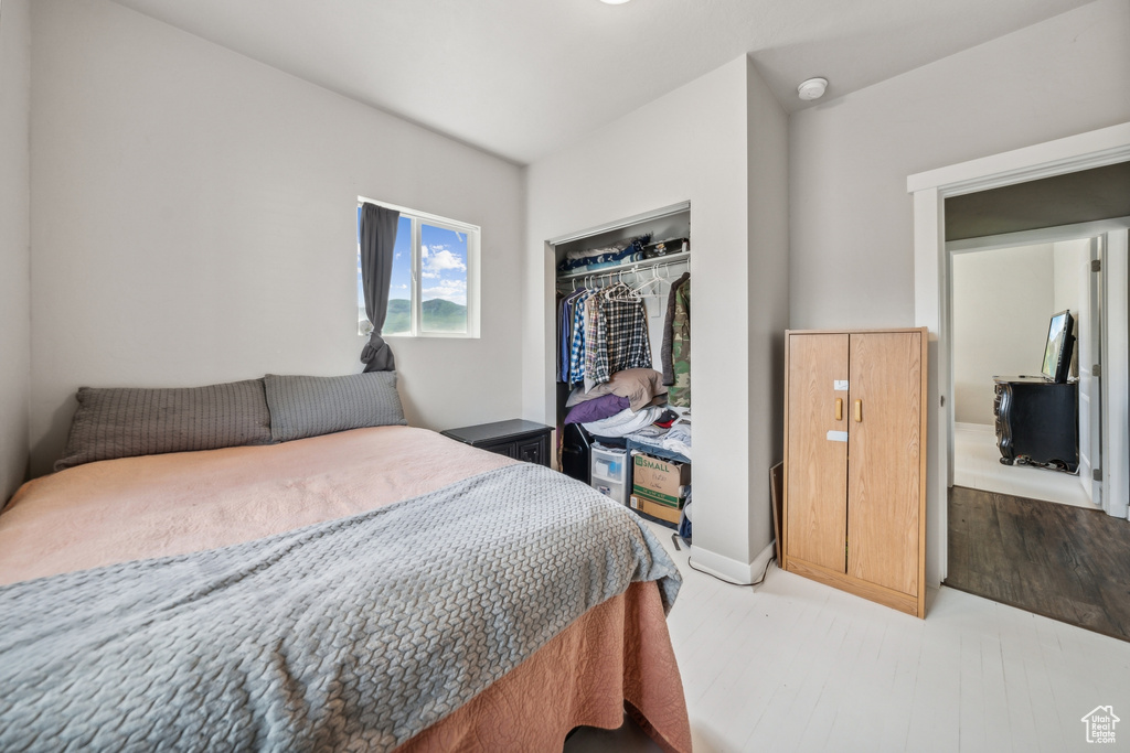 Bedroom with hardwood / wood-style floors and a closet