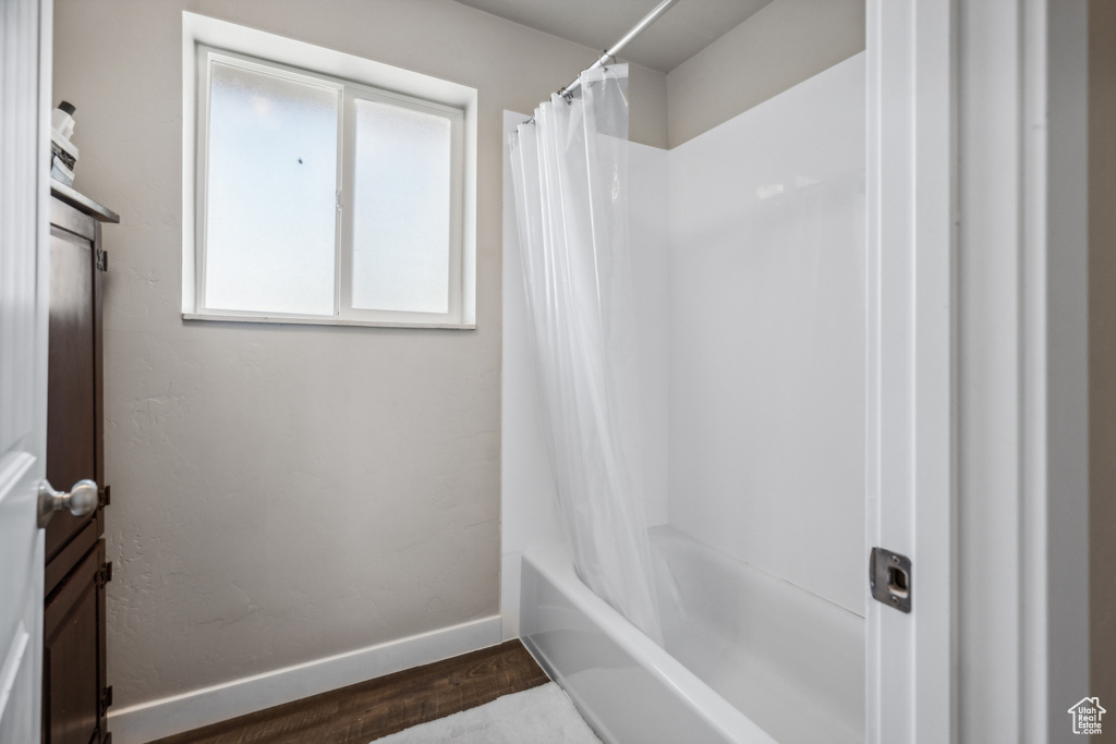 Bathroom with wood-type flooring and shower / bath combo