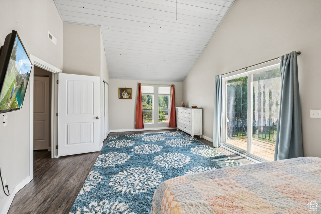 Bedroom with high vaulted ceiling, dark wood-type flooring, and access to outside