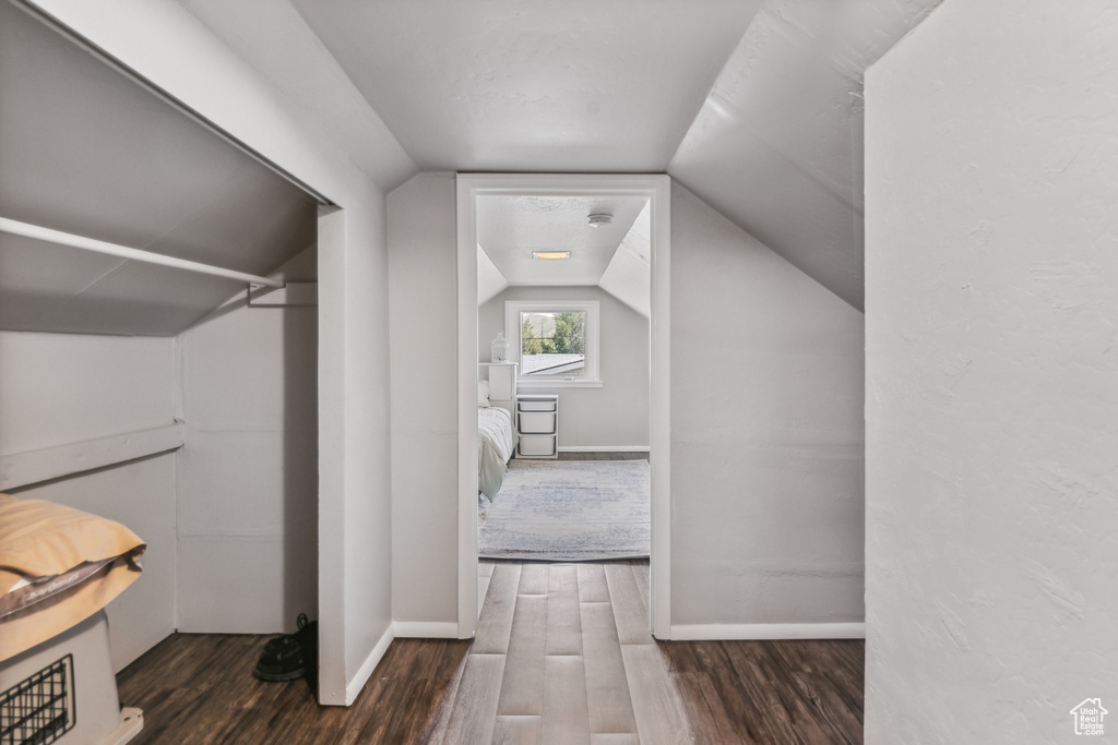 Interior space with dark hardwood / wood-style flooring and lofted ceiling