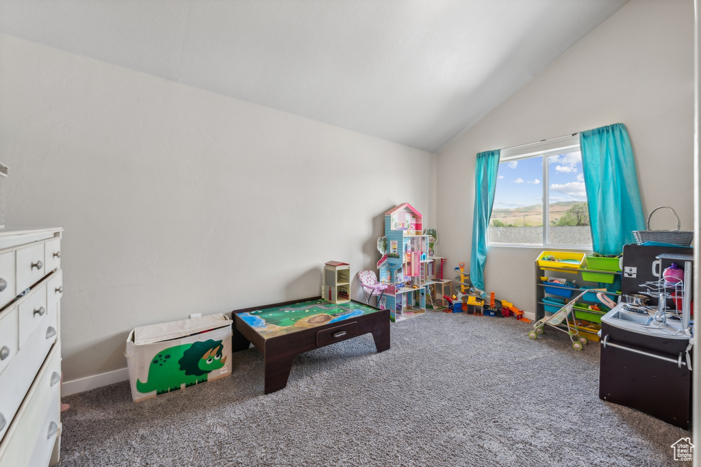 Recreation room featuring vaulted ceiling and carpet flooring