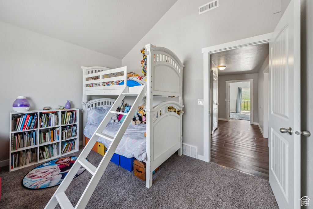 Bedroom with high vaulted ceiling and wood-type flooring