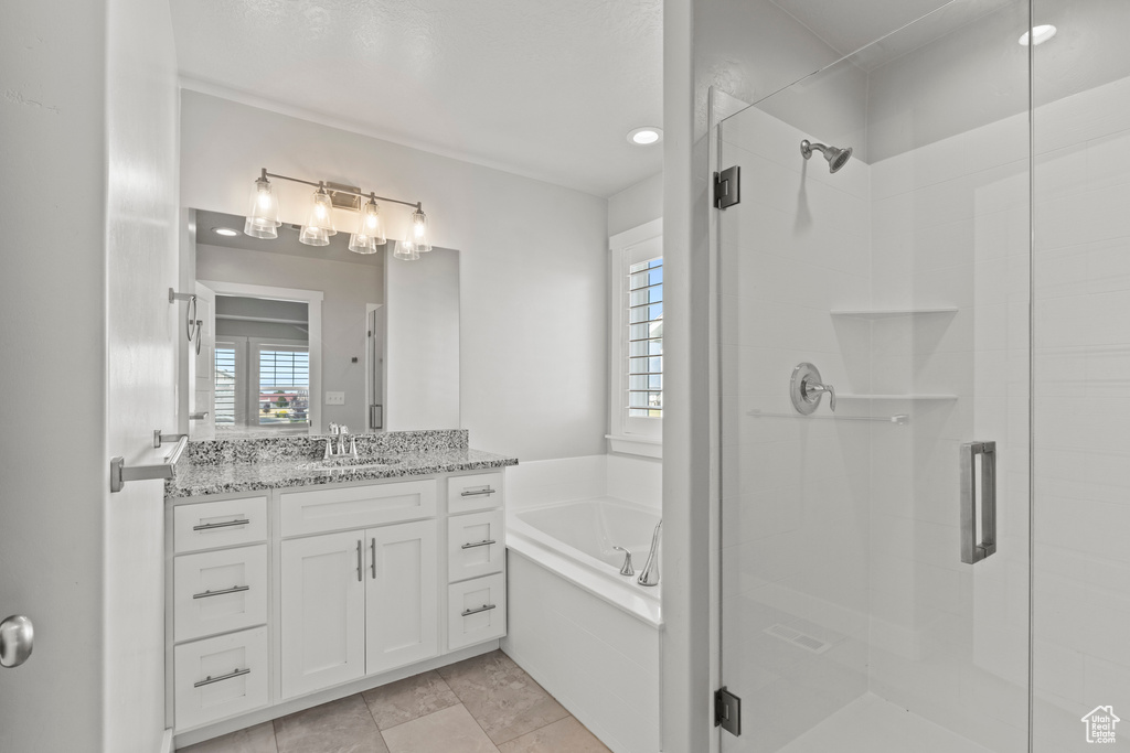 Bathroom featuring vanity and independent shower and bath