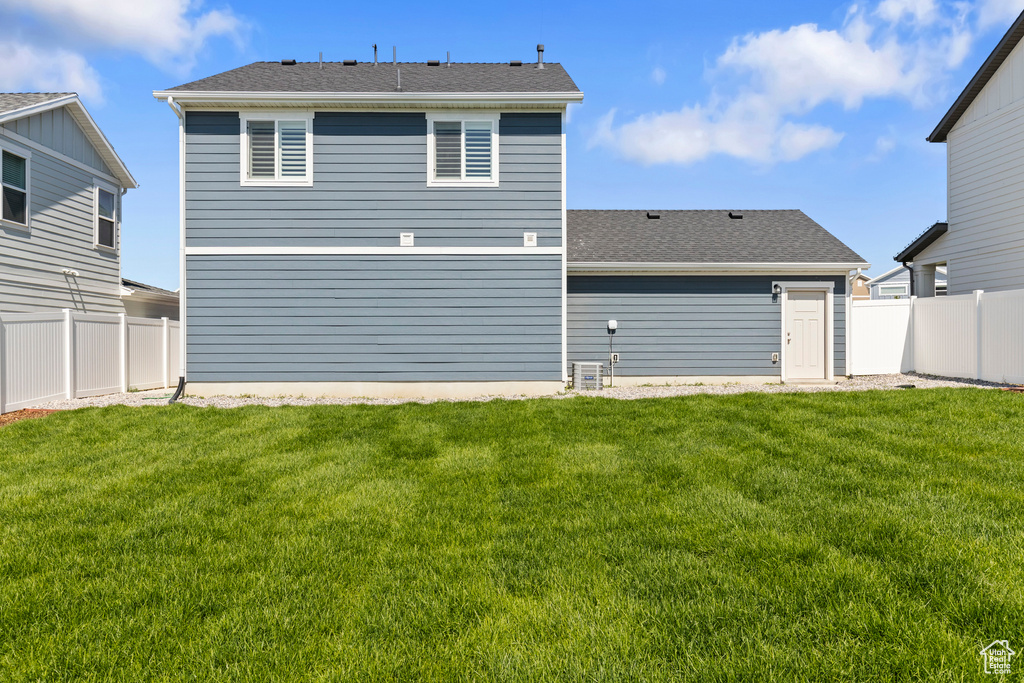 Back of property featuring a lawn