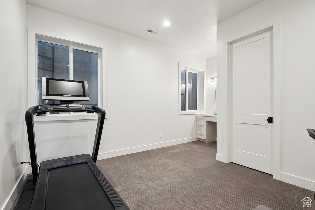 Exercise area featuring carpet and baseboards