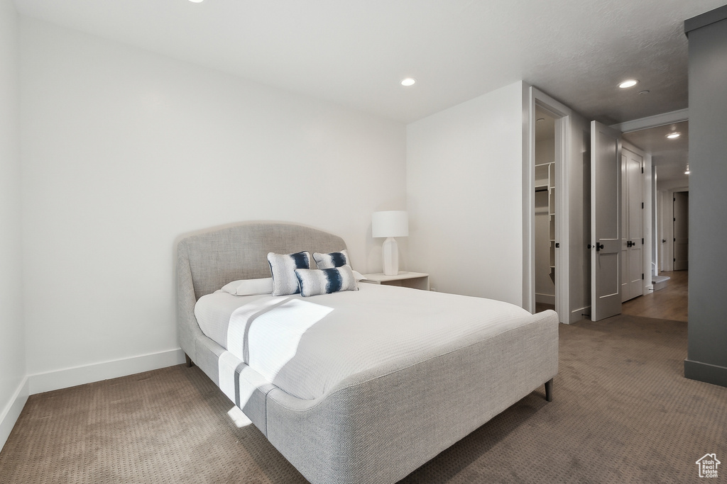 Bedroom featuring carpet floors, baseboards, recessed lighting, and a walk in closet