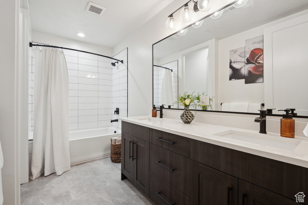 Full bathroom with double vanity and shower / bath combo with shower curtain