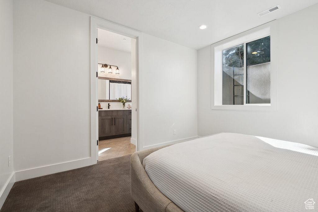 Bedroom with carpet flooring, recessed lighting, baseboards, and ensuite bathroom