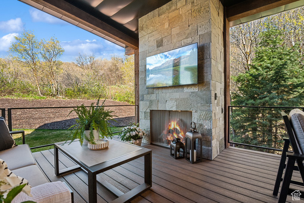 Wooden deck with an outdoor living space with a fireplace