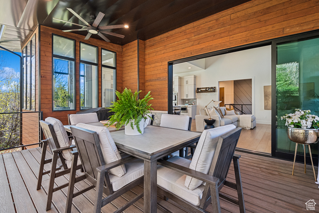 Wooden terrace featuring ceiling fan and outdoor dining area