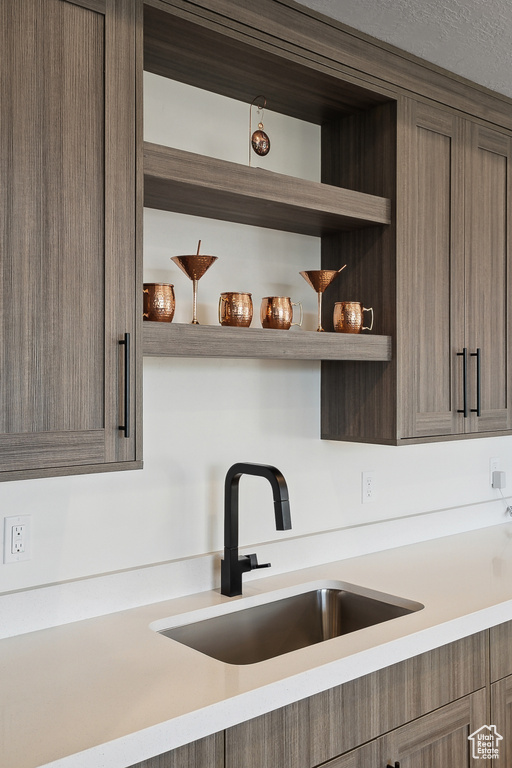 Kitchen with a sink, open shelves, and light countertops