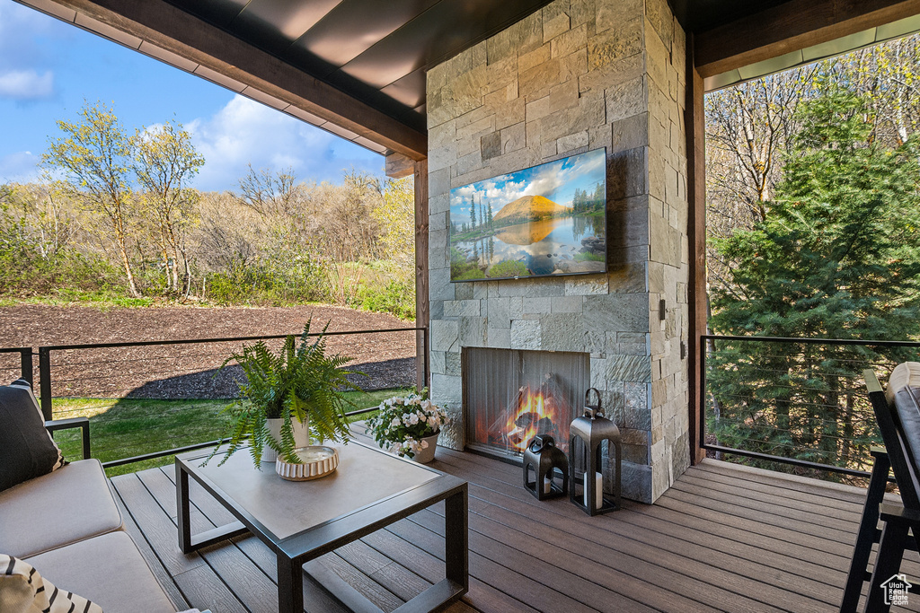 Wooden terrace with an outdoor stone fireplace
