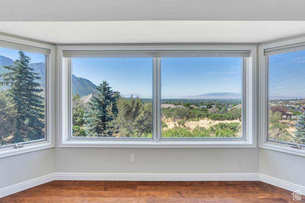 Spare room featuring a wealth of natural light, wood-type flooring, and a mountain view