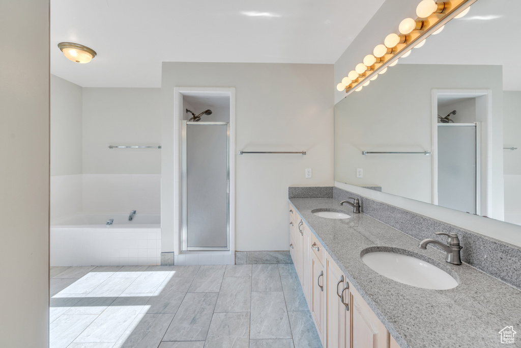 Bathroom with tile floors, plus walk in shower, large vanity, and double sink