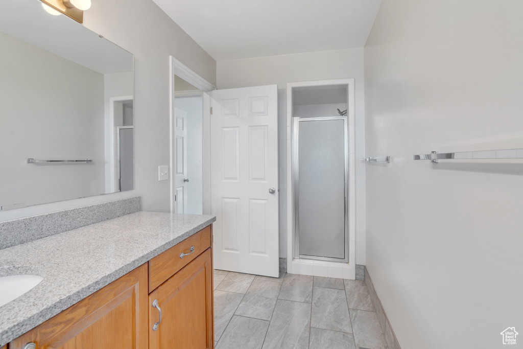 Bathroom featuring an enclosed shower and vanity