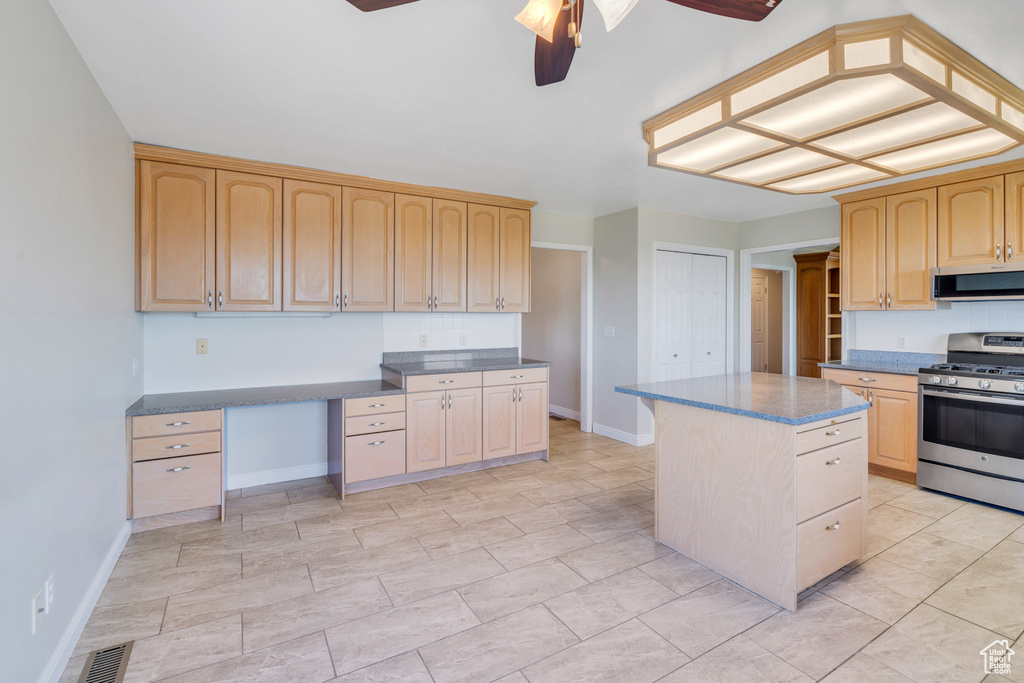 Kitchen with a center island, appliances with stainless steel finishes, light tile floors, ceiling fan, and light brown cabinetry