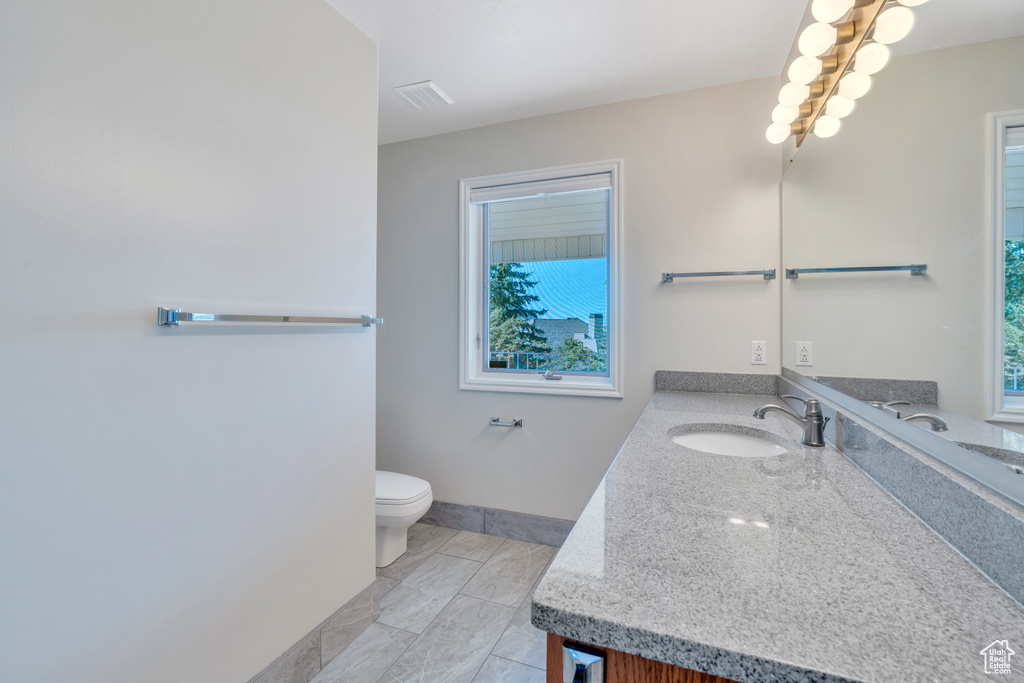 Bathroom featuring tile floors, vanity, and toilet