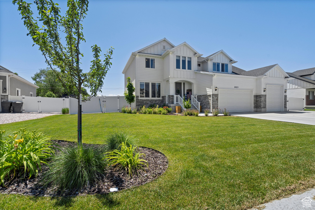 View of front of house featuring a front lawn and a garage