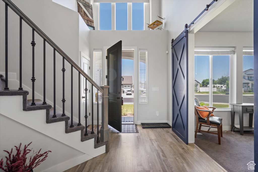 Foyer with a high ceiling, a barn door, and carpet