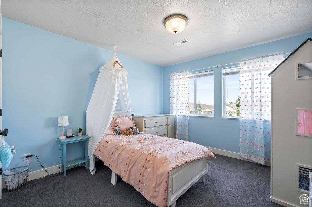 Carpeted bedroom with a textured ceiling