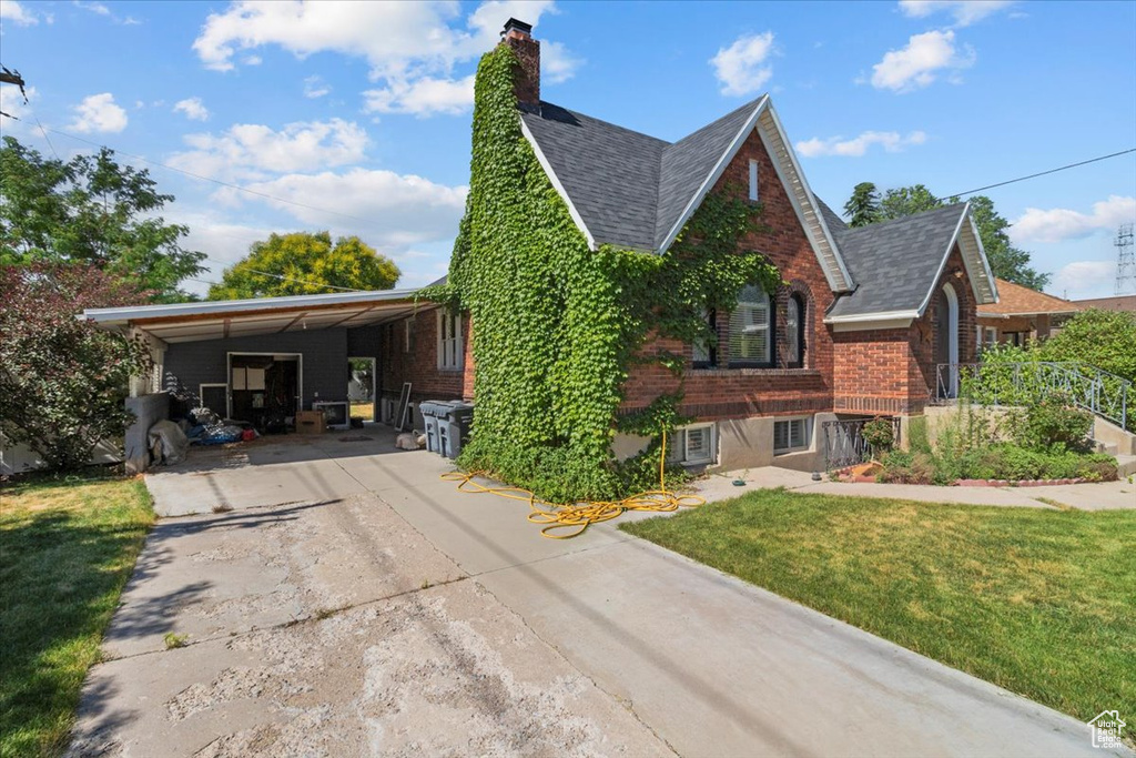 View of front of house with a front yard and a carport