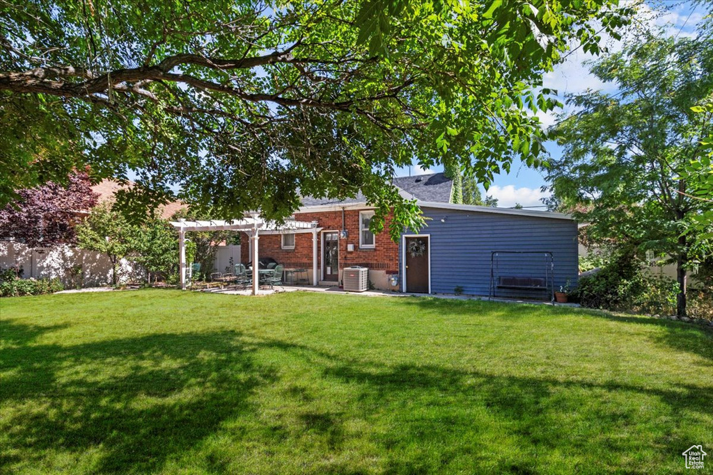 View of yard with a pergola, a patio, and central AC unit